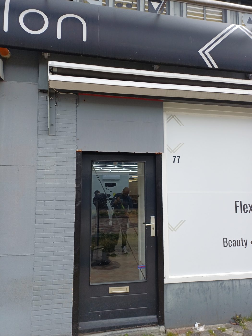 De ingang op nummer 77, onder de luifel van FlexZ Salon