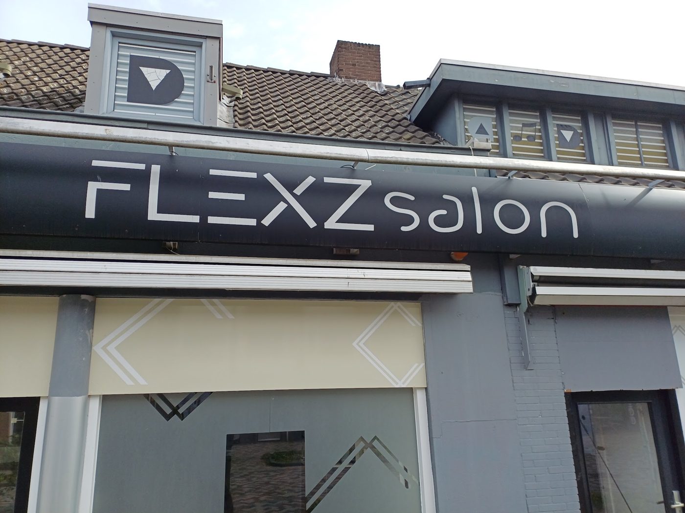 Het FLEXZ salon-bord boven de gevel aan de Geldropseweg